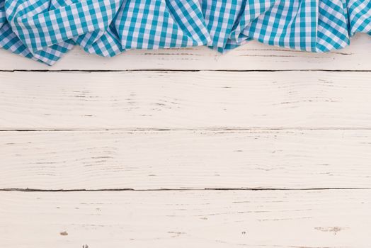 Rustic white wooden table surface with blue checkered cloth, top view