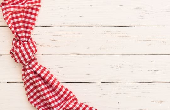 White wooden table background with red knotted tablecloth and copy space