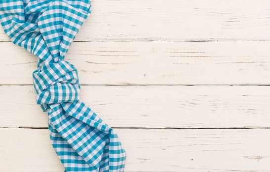 White wooden table background texture with blue checkered tablecloth, high angel view