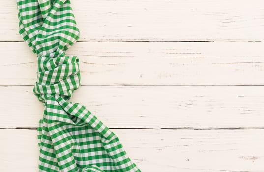 White wooden table background with green checked tablecloth, top view