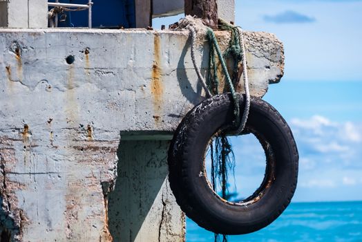 Old used car tires as fender on a shipboard