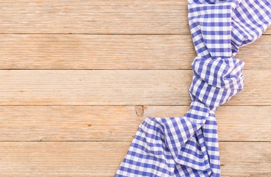 Blue tablecloth on wooden table background, top view with serving size