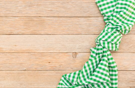 Wooden table background with green checkered tablecloth, high angel view

