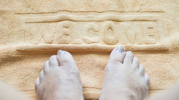 Foot towel with welcome sign on the bathroom floor