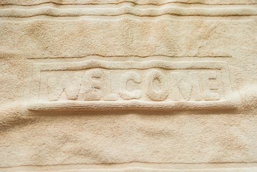 Foot towel with welcome sign on the bathroom floor