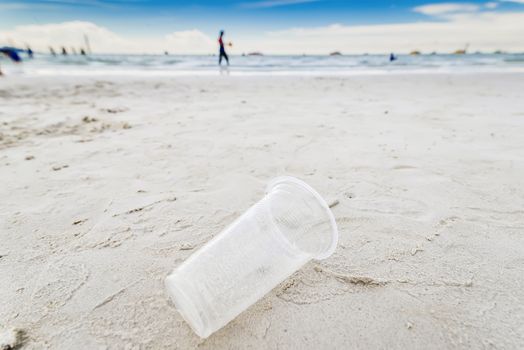 Plastic glass is on the beach leave by tourist