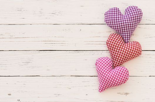 Romantic fabric hearts border for Valentine card on white wood background