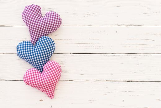 Romantic background for mothers day with three hearts on white wood with copy space