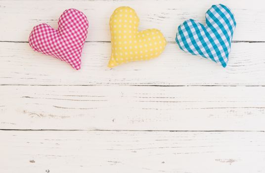 Colorful hearts decoration on white wood background with copy space