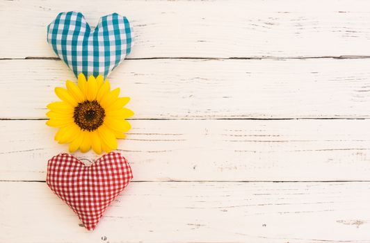 Two love hearts with flower on white wooden background with copy space