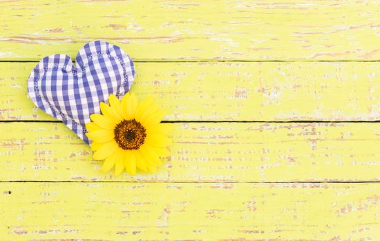 Rustic blue heart with flower on wooden background with copy space