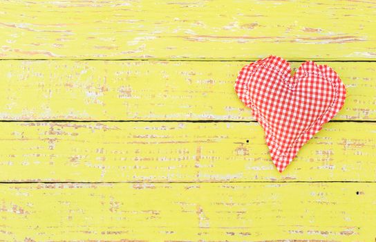 Romantic red heart on yellow wood background for Valentine card with copy space