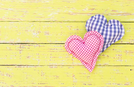 Blue and pink heart on yellow rustic wood with copy space