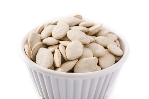 Pumpkin seeds in bowl isolated on white background