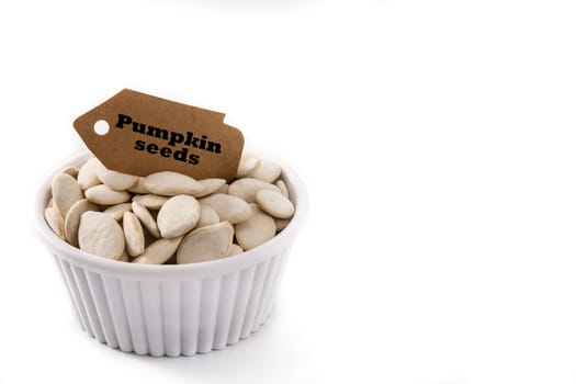 Pumpkin seeds in bowl isolated on white background.