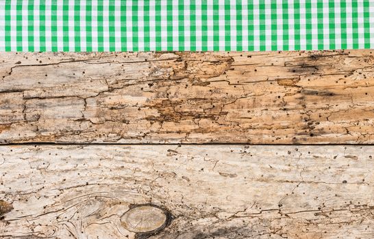 Rustic wooden table surface with green checkered cloth, top view