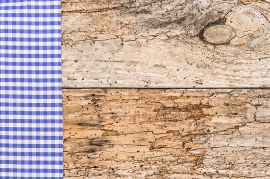 Old wood table background rustic texture, with blue checkered tablecloth, high angel view