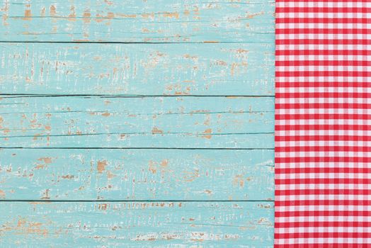 Checkered tablecloth on rustic blue wooden table background