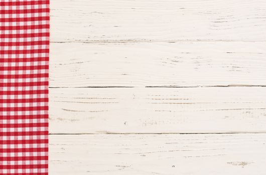 Red checkered napkin on white wooden kitchen table background