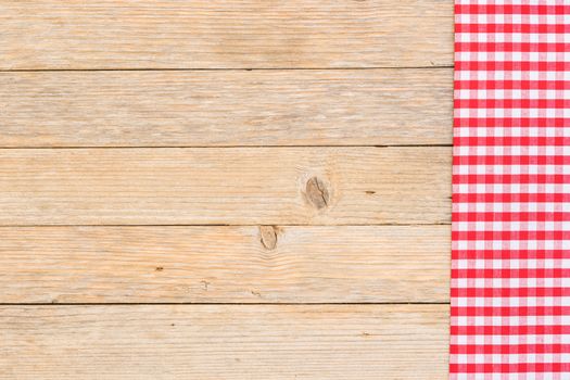 Red checkered tablecloth on rustic wooden table background