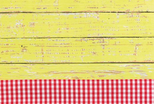 Red checkered tablecloth on rustic green wooden table background