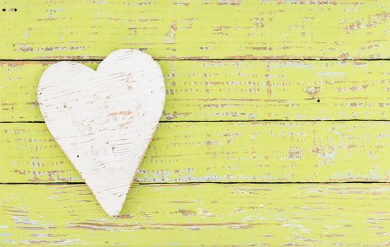 Rustic white heart on colored wooden background with copy space