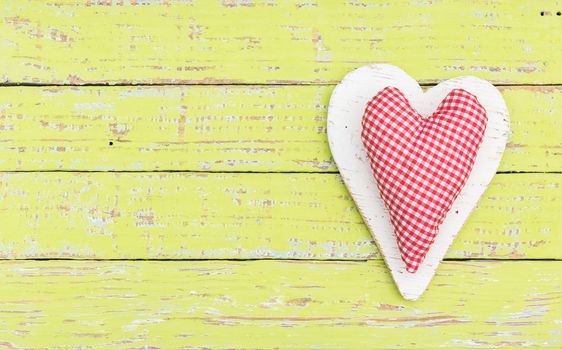 Romantic red heart on yellow wooden background with copy space