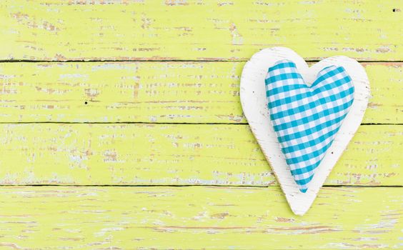 Light blue rustic heart on colored wooden background with copy space