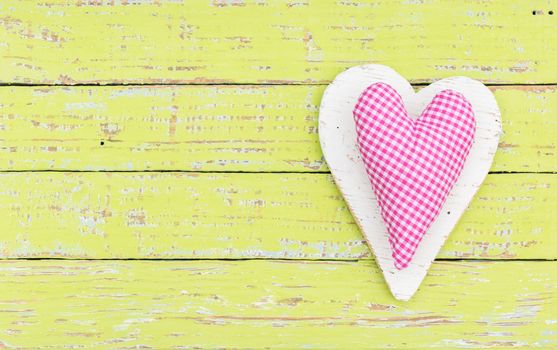 Romantic pink heart on yellow wood background for Valentine card with copy space