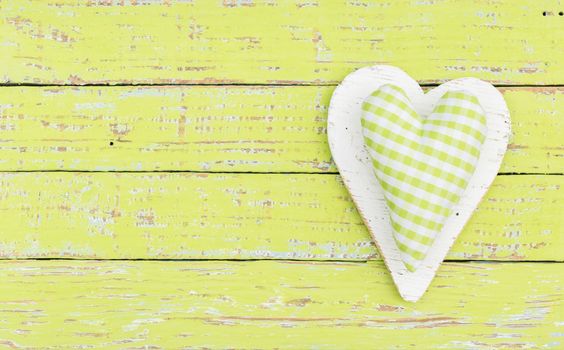 Rustic green heart on wood background with copy space
