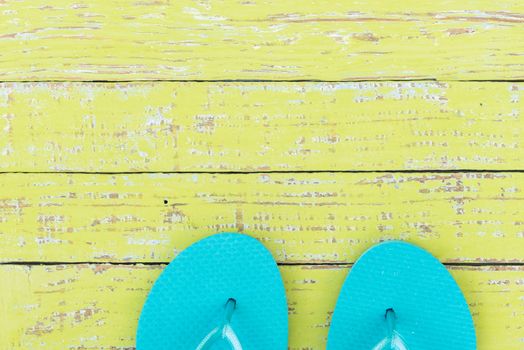 Summer vacation travel concept background with turquoise beach sandals on colored wood