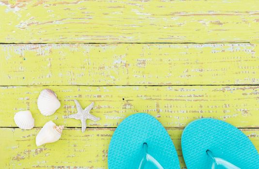 Beach sandals and seashells summer holiday background with copy space