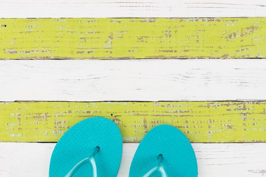 Summer holiday concept background with turquoise beach sandals on wooden deck 

