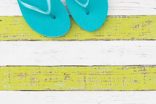 Summer vacation travel concept background with turquoise beach sandals on colored wood