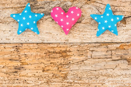 Fabric stars and heart decoration on wooden background with copy space