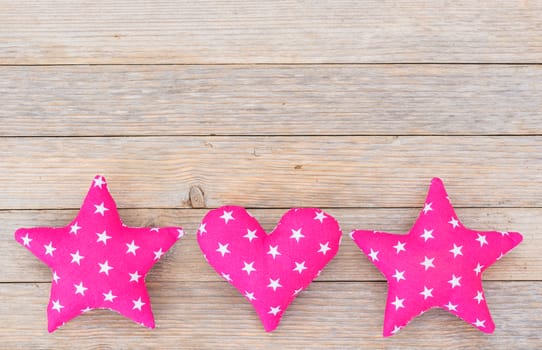 Fabric stars and heart decoration on wooden background with copy space