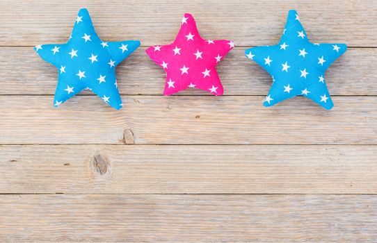 Three fabric stars on wooden background with copy space