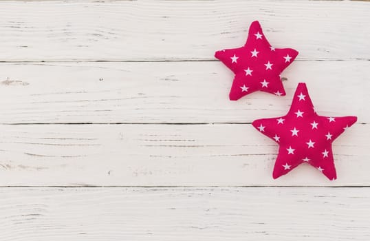 Fabric stars decor on white wooden background with copy space