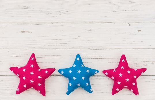 Fabric stars decor on white wooden background with copy space