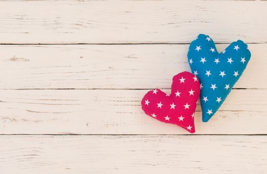 Two love hearts on white wooden background with copy space