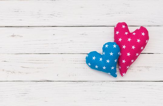 Two love hearts on white wooden background with copy space