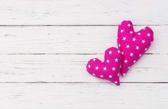 Two love hearts on white wooden background with copy space