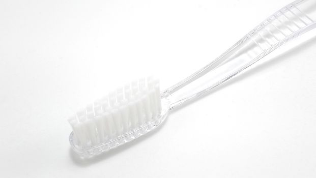 Clear transparent disposable plastic toothbrush use to brush teeth with toothpaste