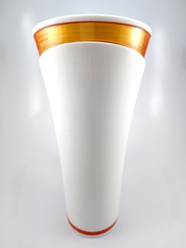 Orange and white color long plastic drinking cup with handle use to drink water content 