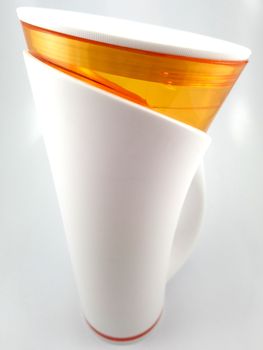 Orange and white color long plastic drinking cup with handle use to drink water content 