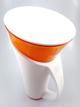 Orange and white color long plastic drinking cup with handle use to drink water content 