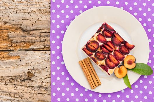 Piece of plume cake on plate on rustic wooden table background, top view