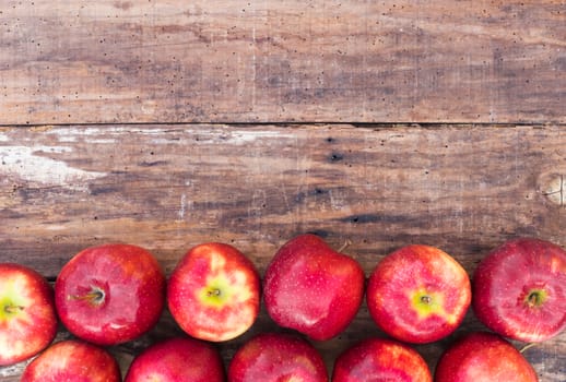 Ripe red apple fruits on rustic wood background with copy space