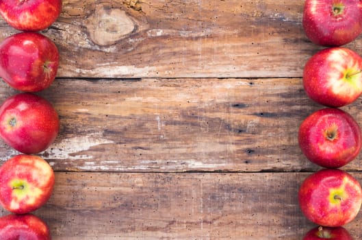 Ripe red apple fruits on rustic wood background with copy space