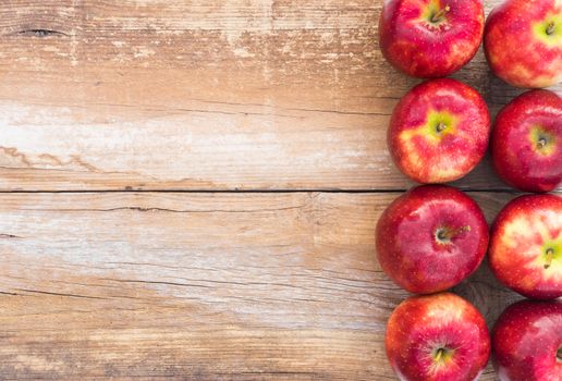 Juicy red apple fruits on rustic wood background with copy space